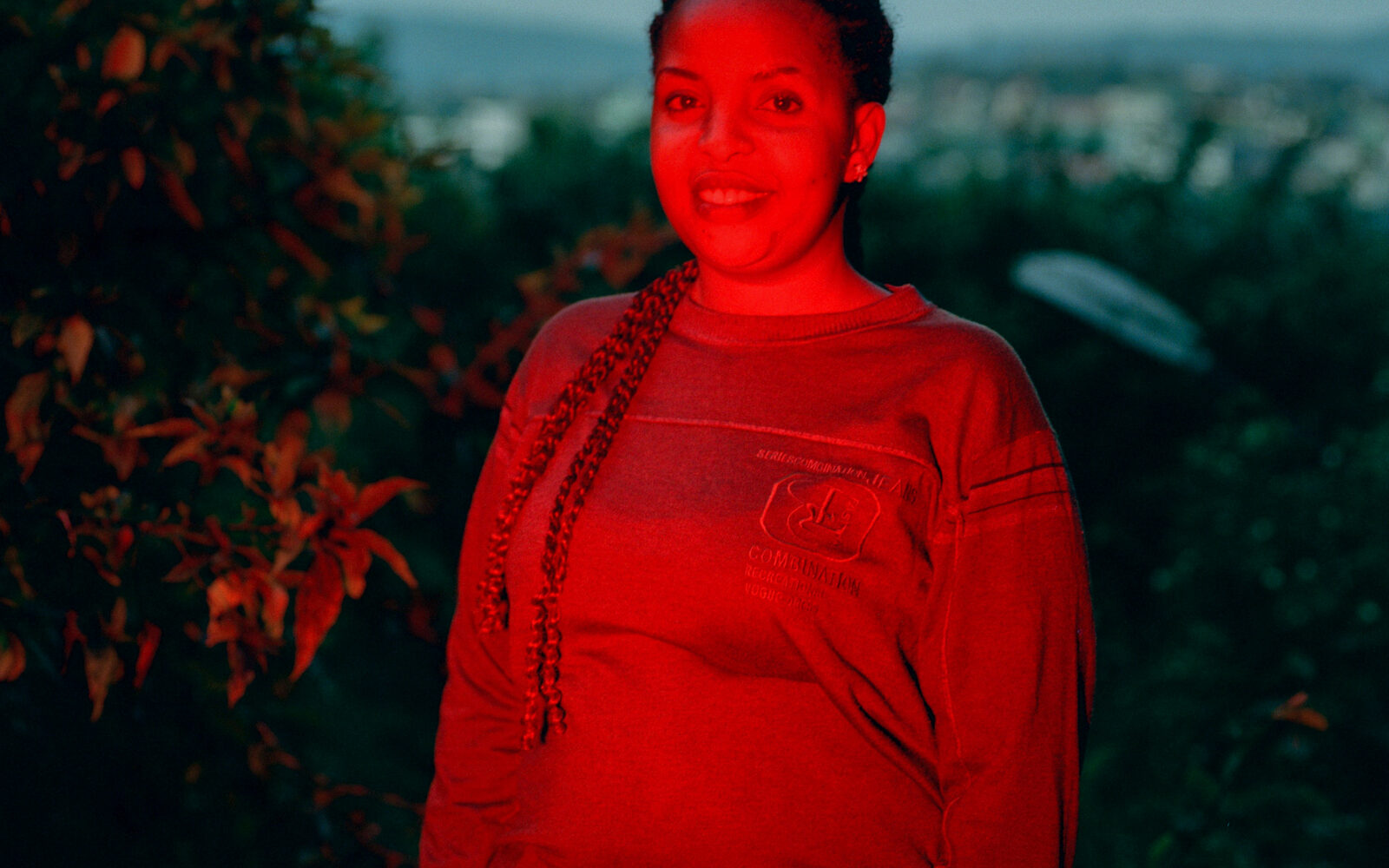 Portrait of a woman lit by red light outdoors